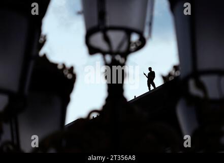 Silhouette of a man standing on a rooftop in Skopje taking photos with his mobile Stock Photo