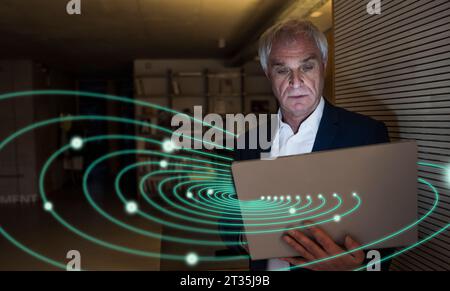 Digital composite image of senior businessman using laptop with swirl lights Stock Photo