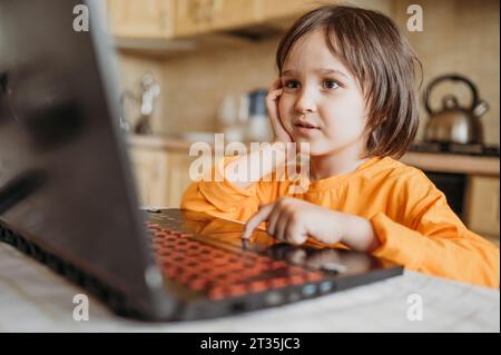 Curious boy using laptop at home Stock Photo