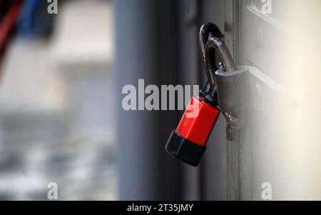 Padlock on an old forged black metal door with stripes and rivets. Vintage background closeup. Stock Photo