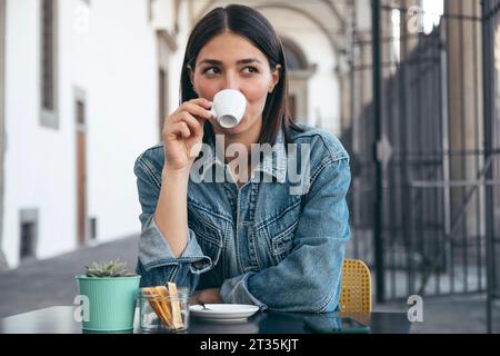 Happy woman drinking coffee at cafe Stock Photo