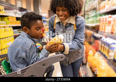 Happy mother shopping with son in supermarket Stock Photo