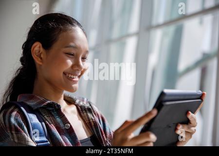 Smiling student using tablet PC in university Stock Photo