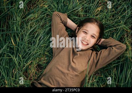 Smiling boy lying on grass in field Stock Photo