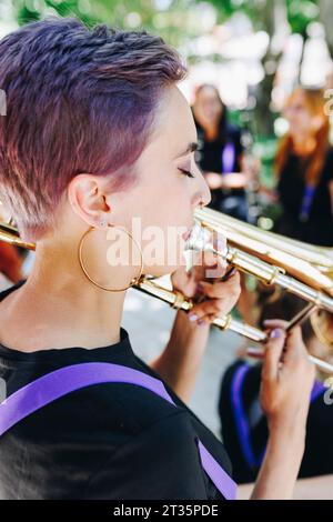 Woman playing trombone with eyes closed Stock Photo