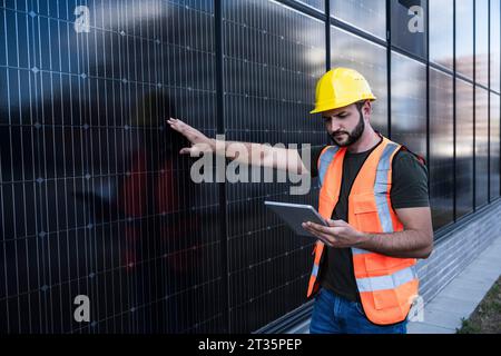 Engineer examining solar panels using tablet PC Stock Photo
