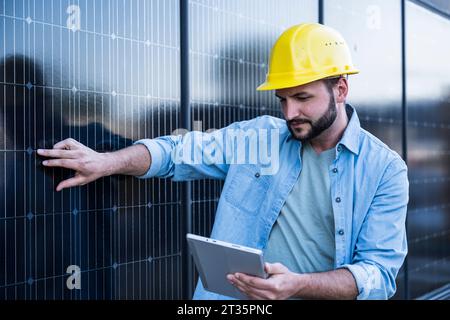 Engineer examining solar panels using tablet PC Stock Photo