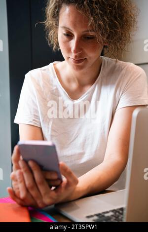 Businesswoman using smart phone at cafe Stock Photo