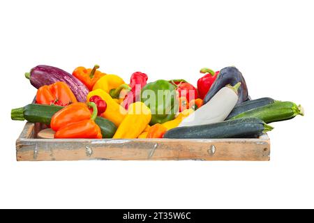 Wooden crate with sweet peppers, aubergines and courgettes isolated on a white background Stock Photo