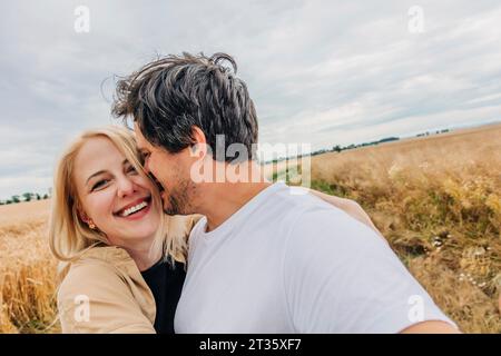 Smiling couple hugging in wheat field Stock Photo