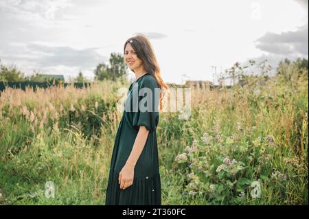 Smiling woman spending leisure time in field Stock Photo