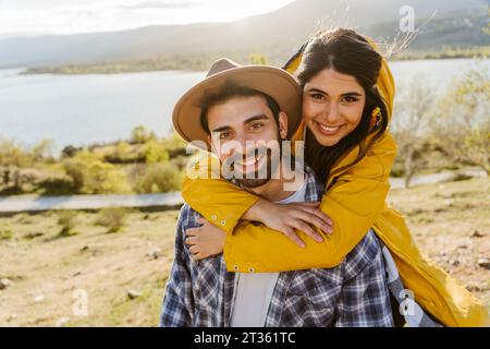 Smiling woman with with arms around man wearing hat Stock Photo