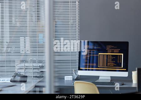 Computer with text on screen at desk in office Stock Photo