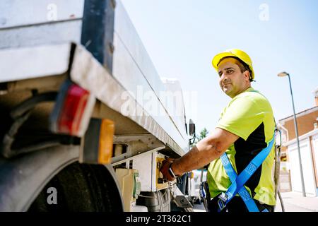 Engineer standing by truck on sunny day Stock Photo