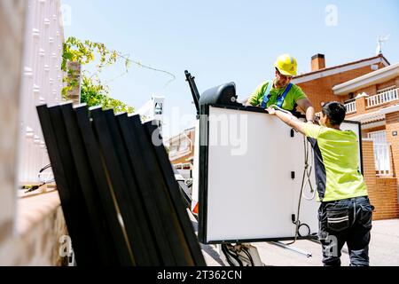 Engineers working with solar panels on sunny day at site Stock Photo