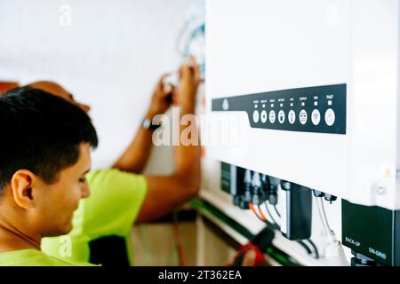 Engineers installing system in utility room Stock Photo
