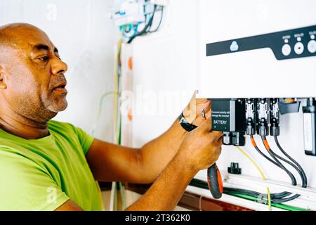 Mature engineer installing system in utility room Stock Photo