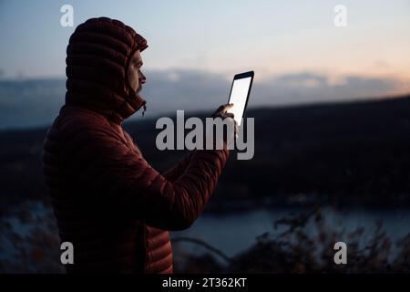 Mature man using tablet PC at dusk Stock Photo