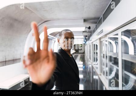 Young woman doing peace gesture at metro station Stock Photo