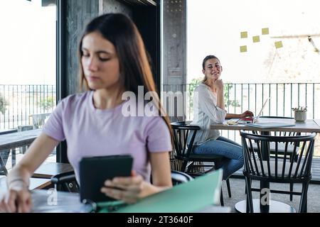Two young women working at coworking space Stock Photo