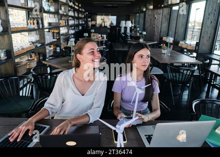 Young women testing solar panel while working at coworking space Stock Photo