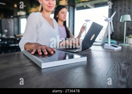 Hand of young woman testing solar panel while working at coworking space Stock Photo