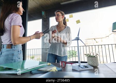 Two young women working together on project at coworking office Stock Photo