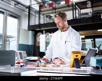Smiling scientist working on circuit board in laboratory Stock Photo