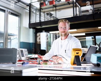 Smiling scientist with electronic equipment in laboratory Stock Photo