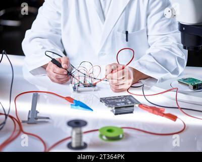 Hands of scientist working on circuit board Stock Photo