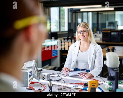 Smiling scientists working on workbench in laboratory Stock Photo