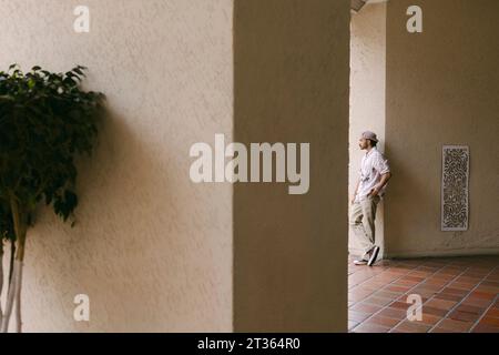 Thoughtful young man leaning on wall Stock Photo