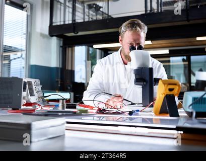 Scientist examining through microscope in laboratory Stock Photo