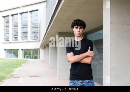 Young man with arms crossed standing near building Stock Photo