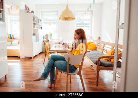 Redhead woman using tablet PC at home Stock Photo