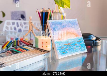 Painting near multi colored pencils at table Stock Photo