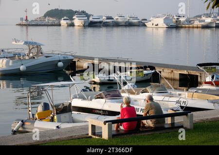 Senior couple sitting on a bench near the yacht harbour of Vrsar, Istria, Croatia Stock Photo