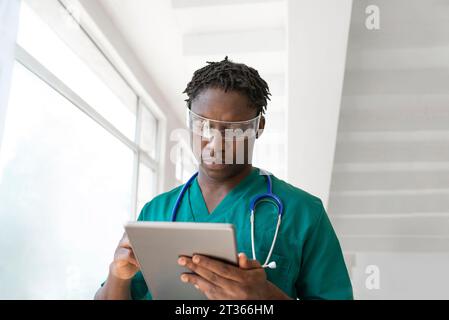 Young doctor wearing smart glasses and using tablet PC in hospital Stock Photo