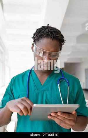 Doctor wearing futuristic glasses and using tablet PC in hospital Stock Photo
