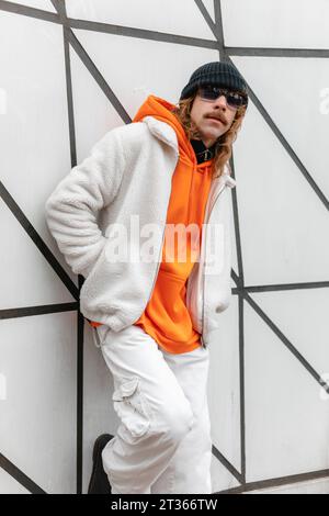 Young man wearing sunglasses leaning on wall Stock Photo