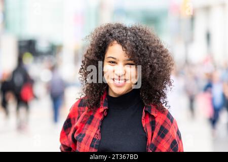 Smiling young woman with curly hair Stock Photo