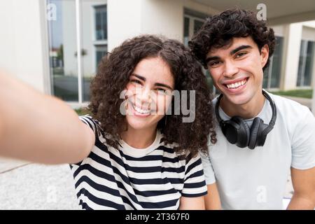 Happy students taking selfie near building Stock Photo
