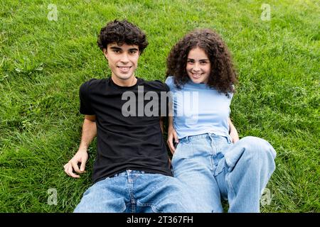 Happy young couple relaxing on grass Stock Photo