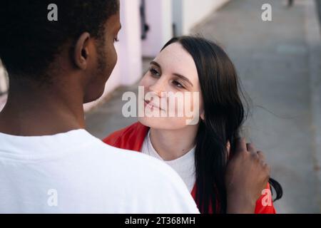 Smiling young woman looking at man Stock Photo