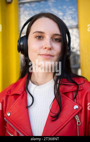 Smiling young woman wearing wireless headphones Stock Photo