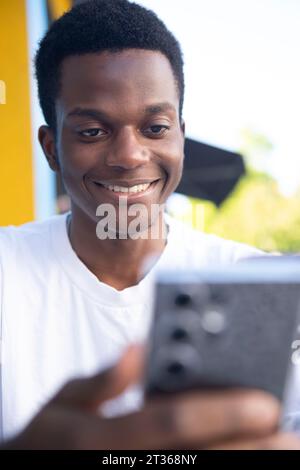 Smiling young man using mobile phone Stock Photo