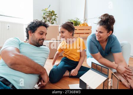 Happy family talking at model house at home Stock Photo