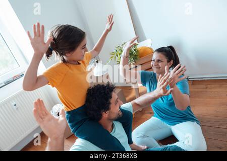 Happy family giving high-five to each other and having fun at home Stock Photo