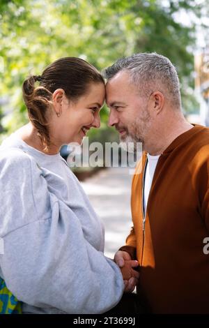 Loving mature couple holding hands at street Stock Photo