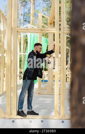 Engineer drilling wood with work tool at site Stock Photo